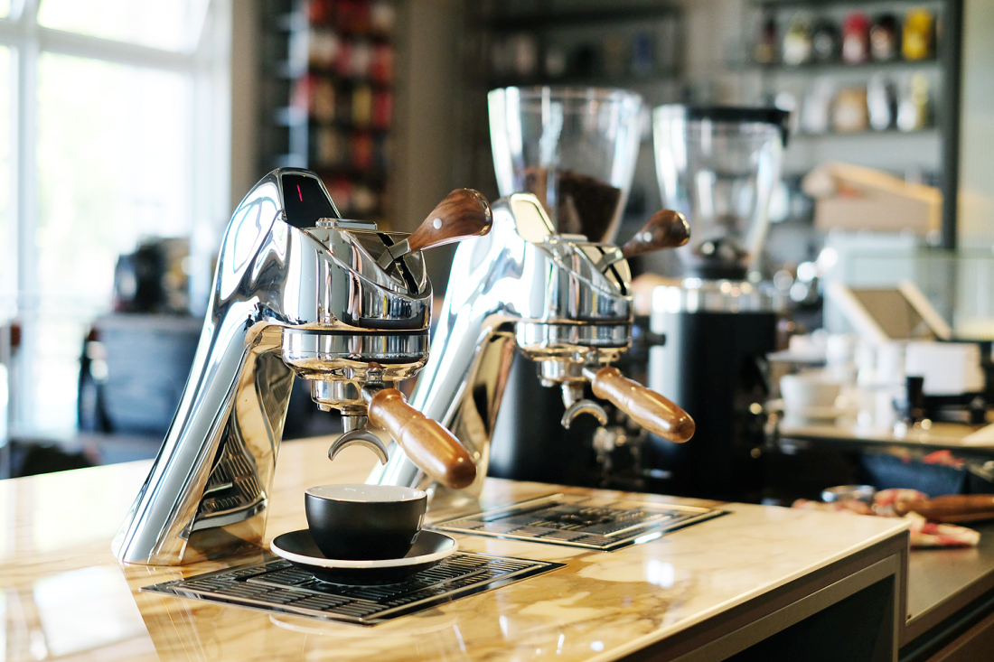 Eine professionelle Kaffeemaschine steht auf einem Workshop-Tisch. 