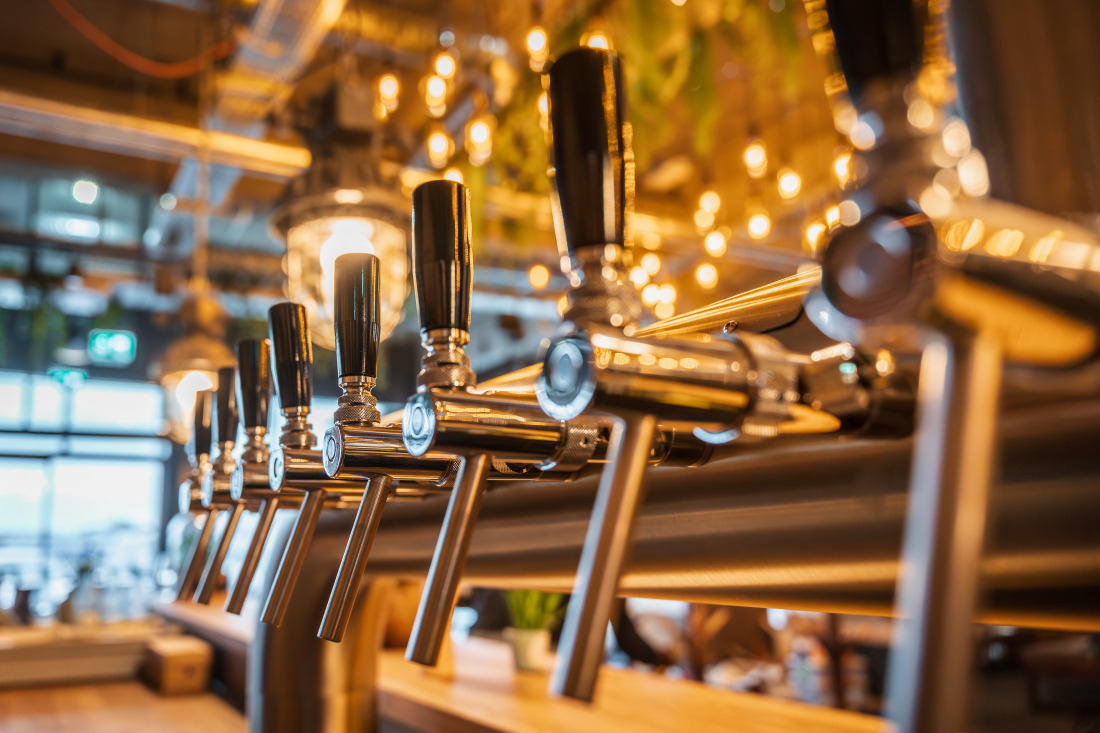 Zapfhähne in der Event-Brauerei Hopfenfänger glänzen im Saallicht.